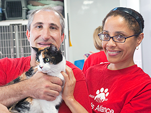 Alliance volunteers, David Glicksman and Lydia Arroyo, introduced Madeline and other adoptable cats and dogs to Brooklyn Cyclones fans on the Alliance adoption van outside of MCU Park at Bark in the Park. (Photo by Joe Galka)