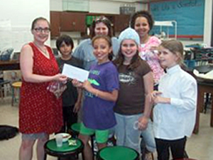 Students present a donation check to Jennifer Stevens, an independent pigeon rescuer.